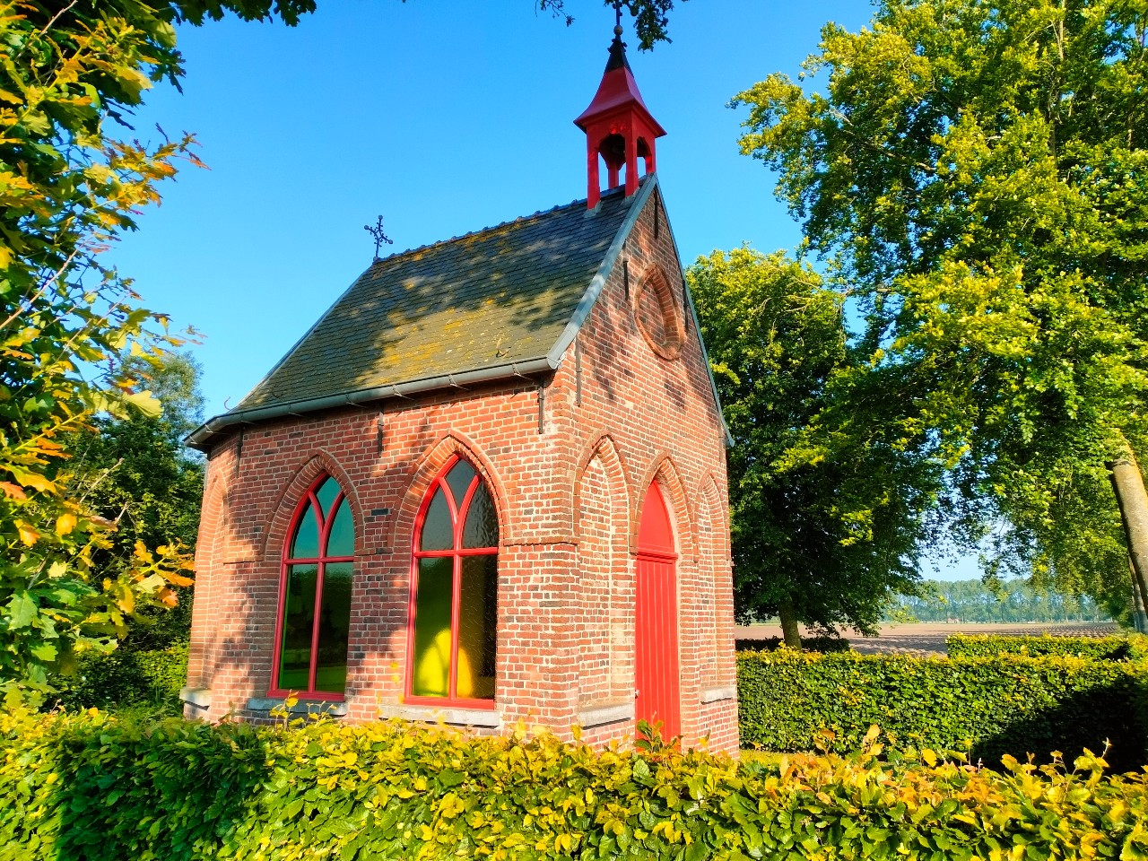 Foto van een kapel met in een groen landschap